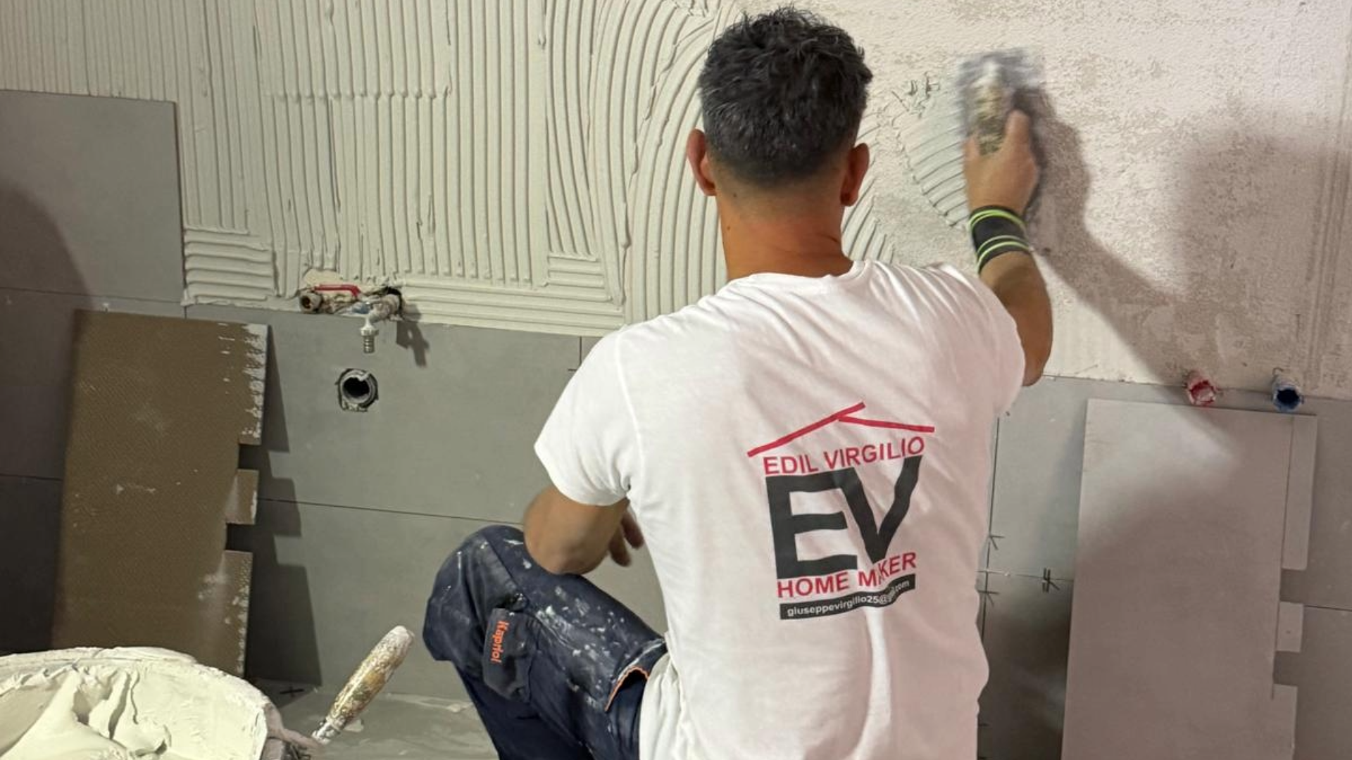 FOTO DI EDILVIRGILIO CHE POSA PIASTRELLE IN UN BAGNO